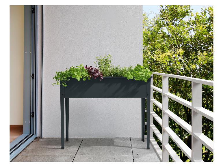 Jardinière surélevée avec herbes aromatiques sur un balcon ensoleillé.