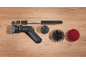 Kit de nettoyage avec brosse électrique, rallonge et divers accessoires sur fond en bois.