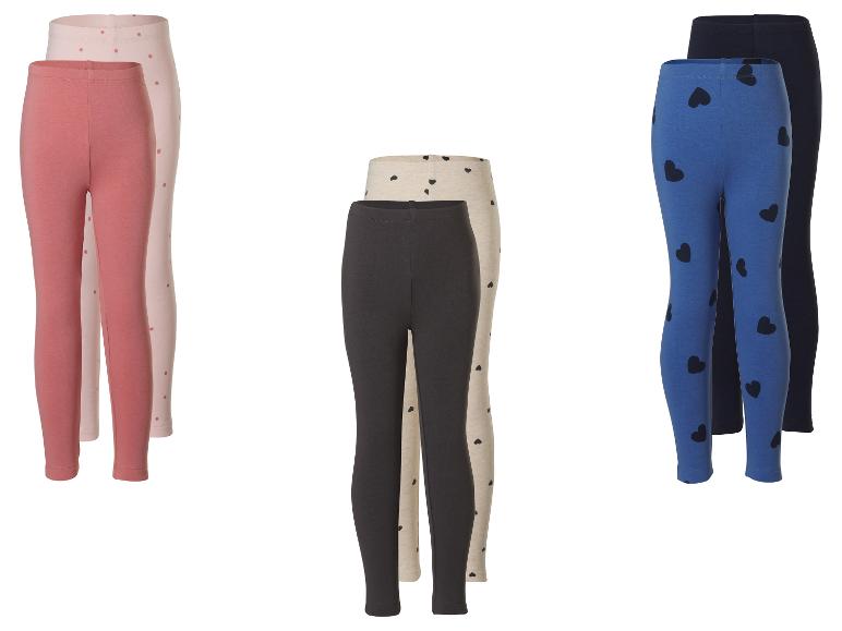 Trois paires de leggings pour enfants : roses à pois, beiges à cœurs et bleus à cœurs.