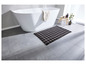 Une baignoire avec un tapis de bain à motif géométrique.