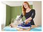 Une femme repasse des vêtements avec un fer à repasser Tefal Express Steam.