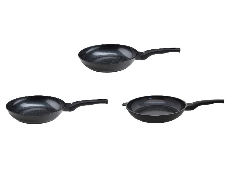 Trois poêles à frire noires avec revêtement antiadhésif et poignées.