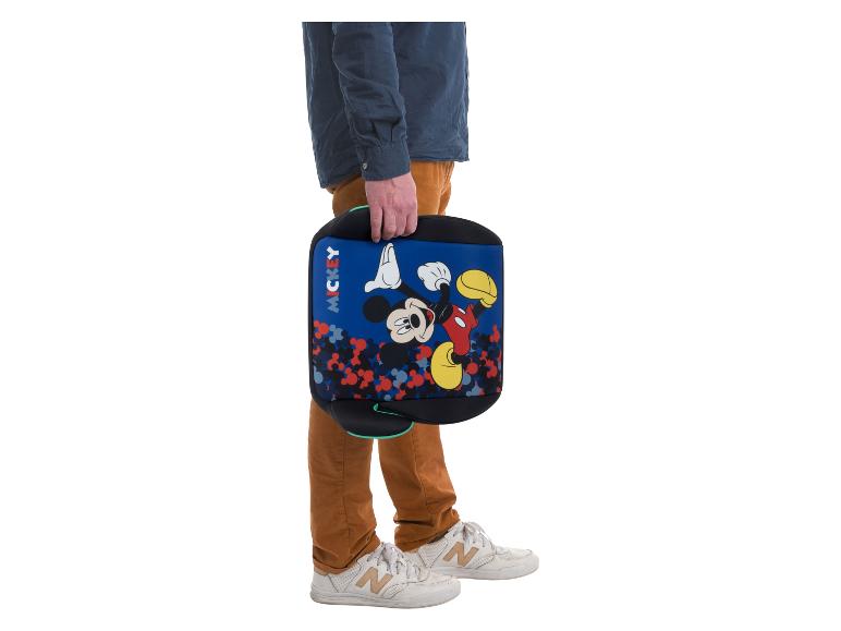 Personne tenant un rehausseur bleu Mickey Mouse avec un motif coloré.