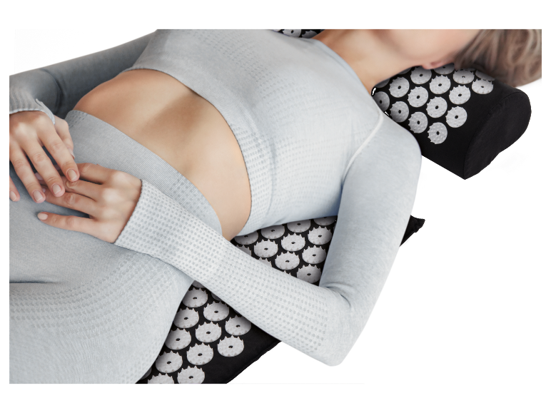 Femme se détendant sur un tapis d'acupression.