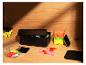 Boîtes de rangement noires et transparentes avec des jouets colorés sur une surface en bois.