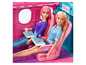 Deux poupées Barbie assises dans un avion jouet rose.