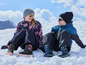 Deux enfants en vêtements d'hiver assis dans la neige.