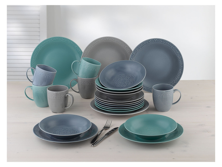 Service de table avec des assiettes bleues et vertes, des bols et des tasses.