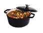 Cocotte en fonte noire avec couvercle, remplie d'un ragoût de viande et de légumes.
