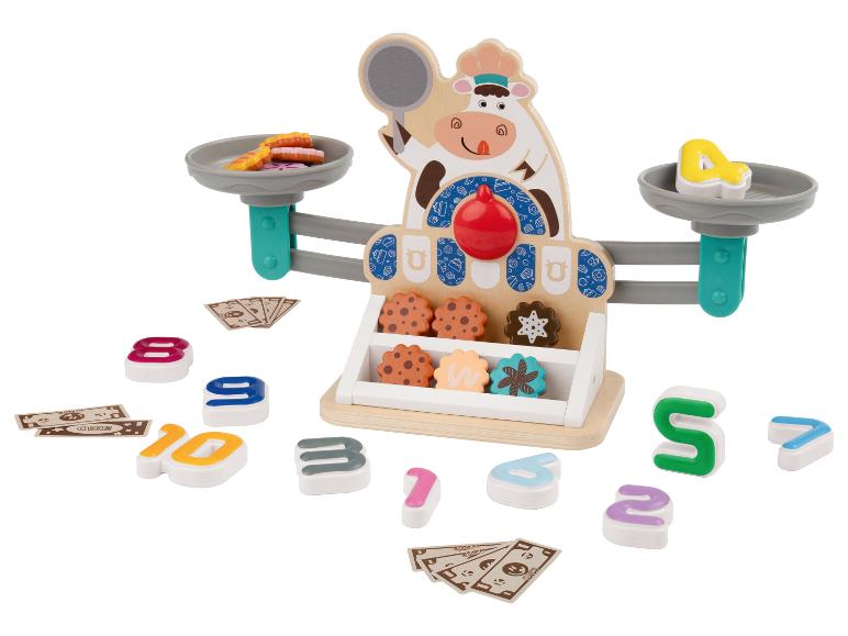 Balance en bois sur le thème de la vache, biscuits, chiffres et argent de jeu.
