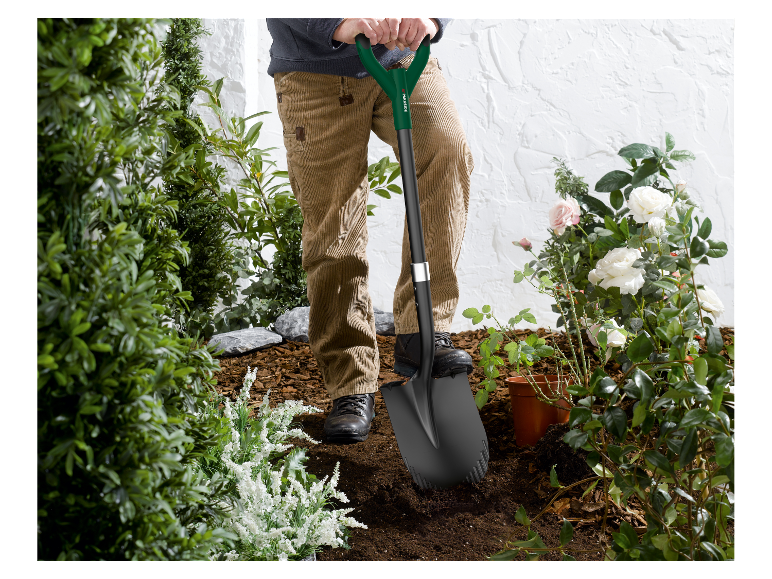 Un homme utilise une pelle Parkside pour jardiner.