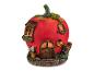 Une petite maison rouge en forme de tomate avec une porte, une fenêtre et une chenille rampante.