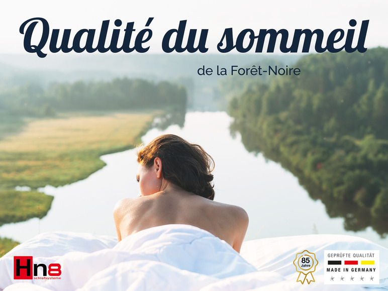 Une femme allongée dans un lit avec le logo Hna et le texte 'Qualité certifiée, fabriqué en Allemagne'.