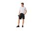 Homme en t-shirt blanc et short noir tenant une gourde.