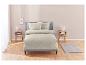 Parure de lit beige avec un motif floral blanc sur un lit.