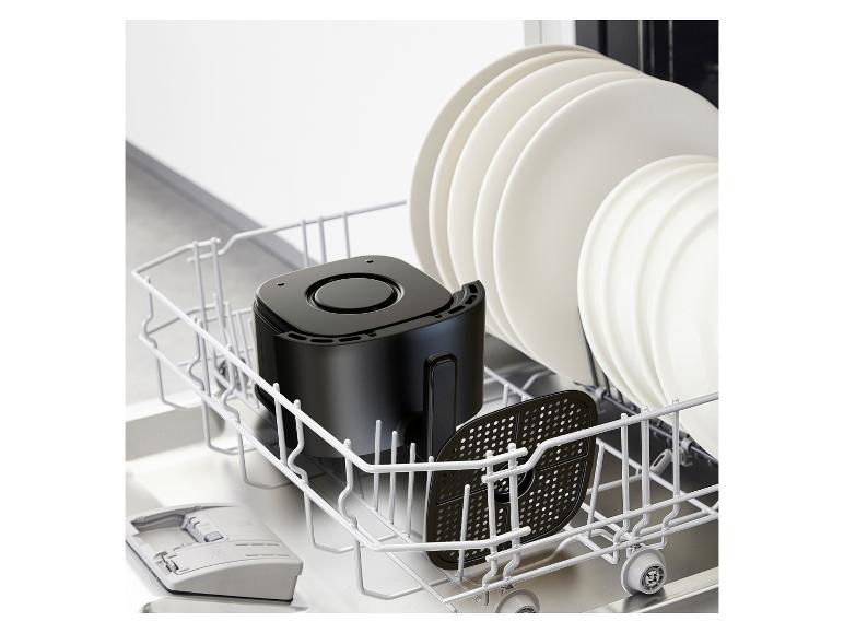 Friteuse à air noire et assiettes dans un lave-vaisselle.