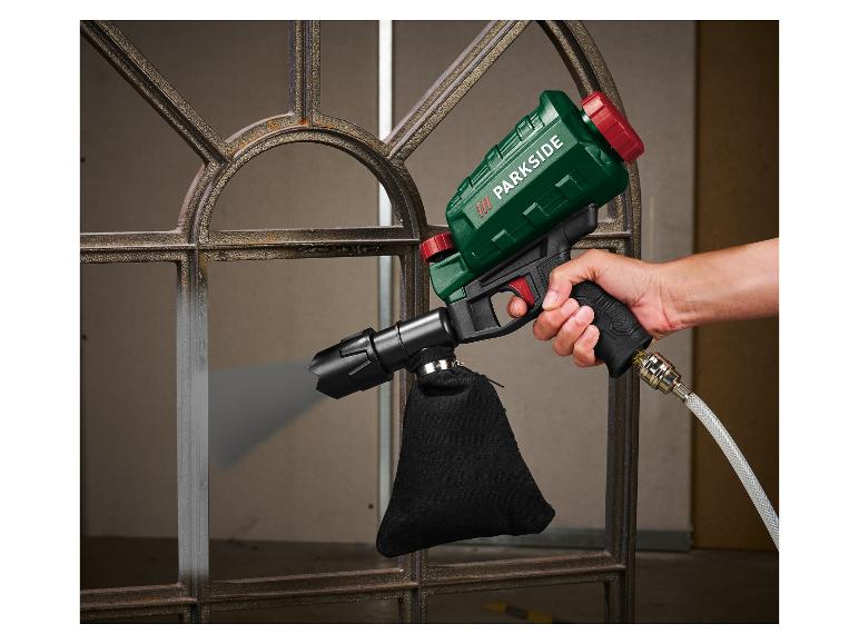 Une personne utilise un pistolet de peinture Parkside pour peindre une fenêtre en métal.