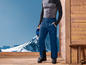 Tenue de ski avec un pantalon bleu, des chaussures de ski noires et des lunettes de ski bleues.
