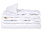 Couette blanche matelassée pliée avec un motif en maille sur les côtés.
