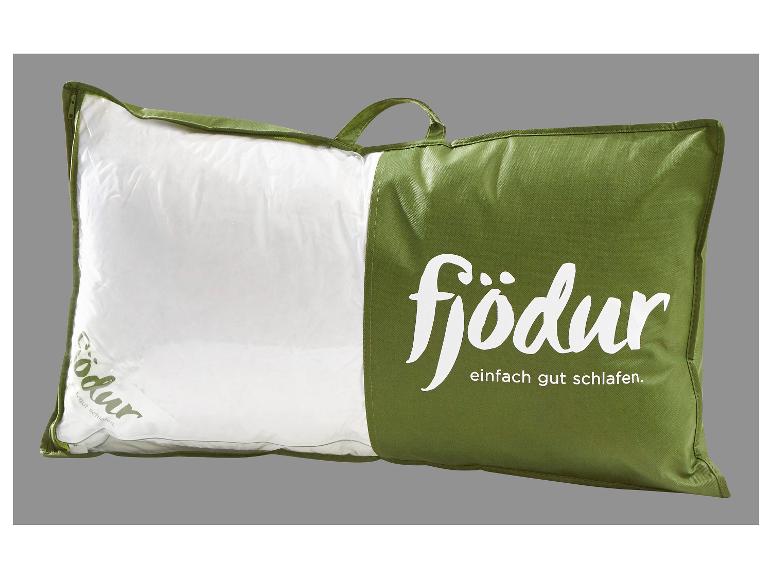 Oreiller blanc dans une housse verte avec fermeture éclair et poignée, avec le texte « fjödur »