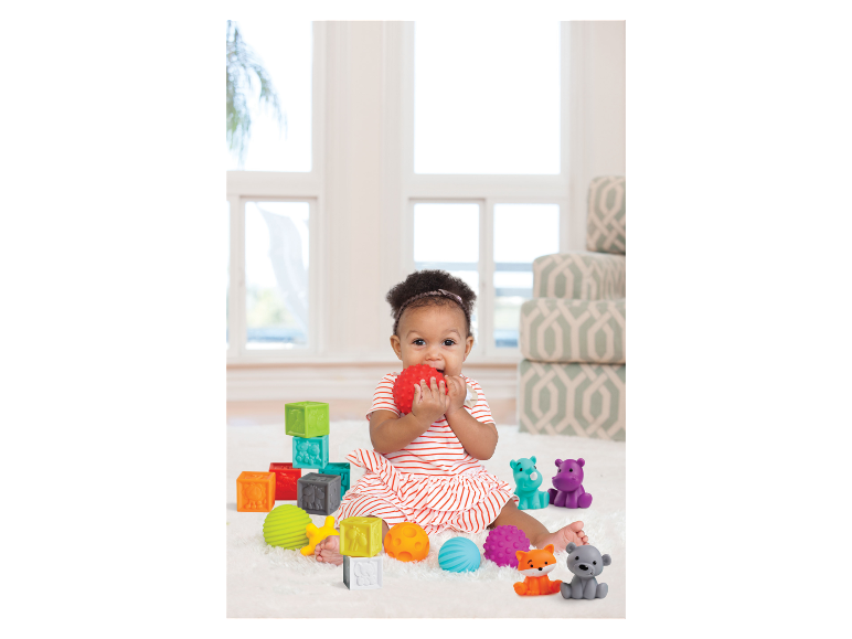 Bébé jouant avec des blocs et des balles sensoriels.
