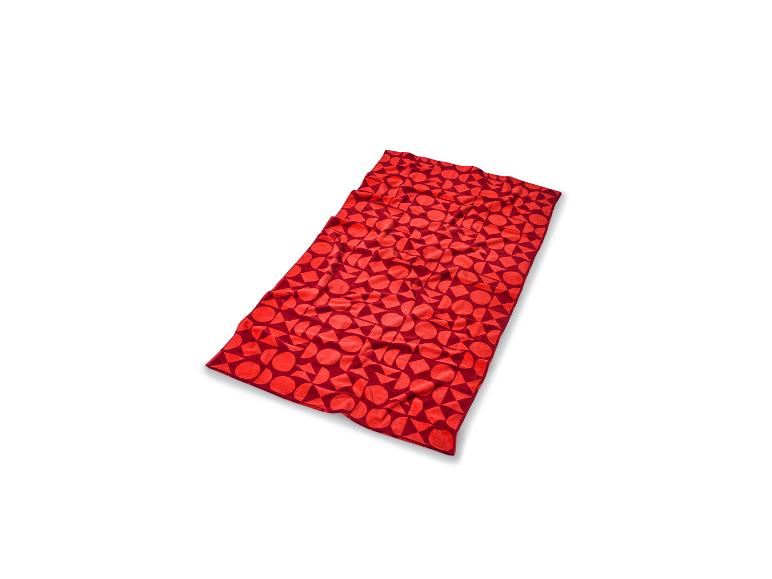 Couverture rouge à motif géométrique sur fond blanc