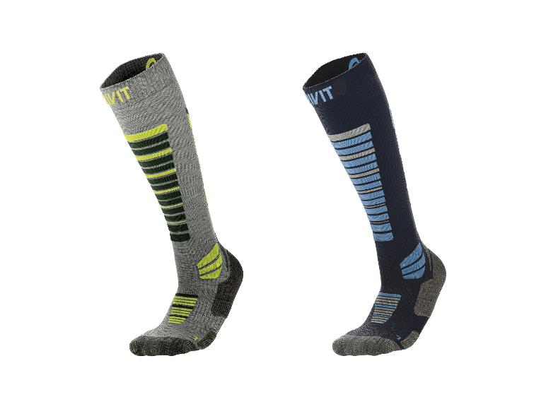 Deux paires de chaussettes de ski, une grise avec du jaune et une bleu foncé avec du bleu clair.