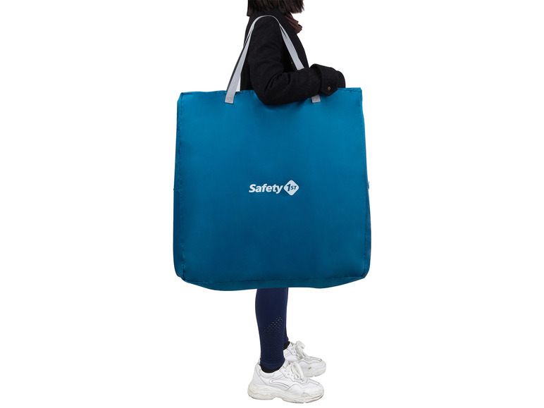 Une femme porte un grand sac bleu Safety 1st.