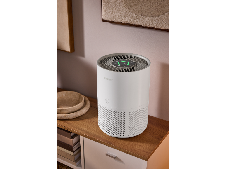 Purificateur d'air cylindrique blanc avec écran numérique sur un buffet en bois