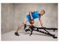 Un homme s'entraîne avec un kettlebell et un banc de musculation réglable.