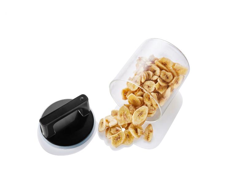 Des tranches de banane séchées dans un bocal en verre avec un couvercle en plastique.