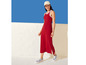 Une femme portant une robe rouge avec des rayures blanches et des baskets bleues.