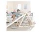 Un jeune enfant joue sur un triangle d'escalade roba avec un toboggan.