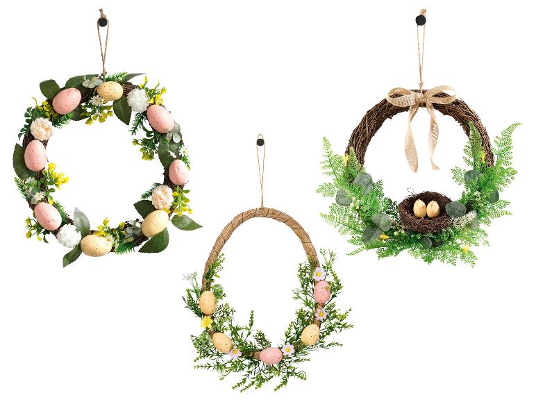 Trois couronnes de Pâques avec des œufs, des fleurs et de la verdure, une avec un nid d'oiseau.