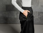 Pantalon noir avec des détails verts, porté par un mannequin.