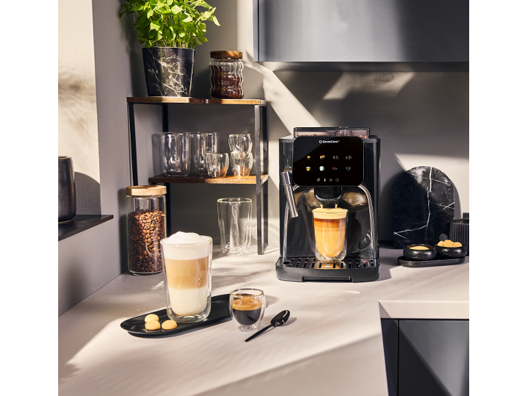 Machine à café automatique avec café et latte macchiato dans une cuisine moderne.