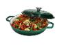 Cocotte en fonte verte avec couvercle, remplie de légumes rôtis