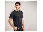 Homme en t-shirt Henley noir et pantalon noir, regardant vers la droite.