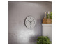 Une horloge blanche Mebus sur un mur en béton.