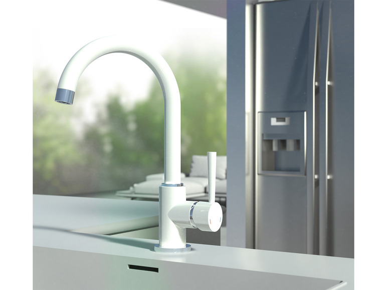 Un robinet de cuisine blanc et un réfrigérateur dans une cuisine moderne.