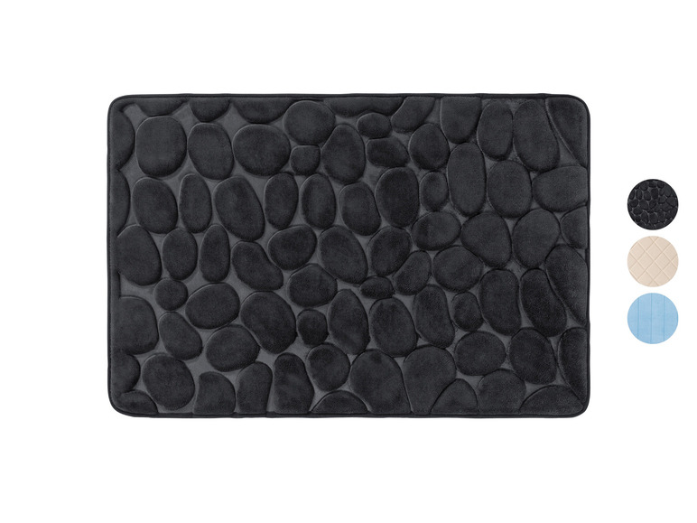 Un tapis de bain noir avec un motif en relief de pierres rondes.