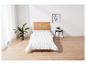 Une couette blanche avec un motif en losange matelassé sur un cadre de lit en bois.