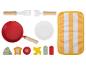 Une poêle rouge, une assiette, des jouets en bois pour cuisiner et un torchon.