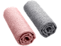 Deux serviettes roulées, une rose et une grise, sur fond noir.