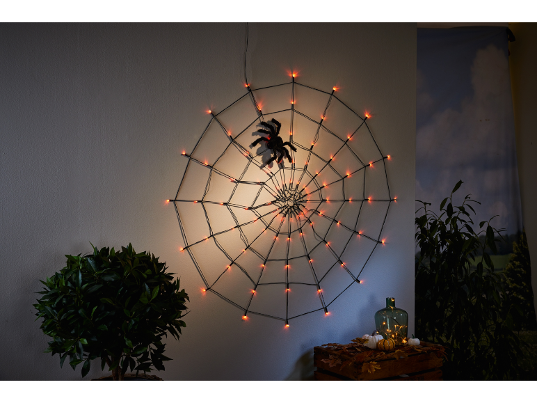 Toile d'araignée lumineuse d'Halloween avec araignée, citrouilles et décorations d'automne.