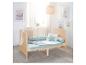 Lit bébé en bois avec literie bleue et décorations murales d'animaux.