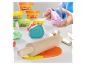 De la pâte à modeler Play-Doh et des outils en bois dans les mains d'un enfant.