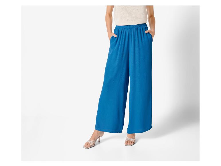 Pantalon large bleu et sandales à talons : mode féminine élégante.