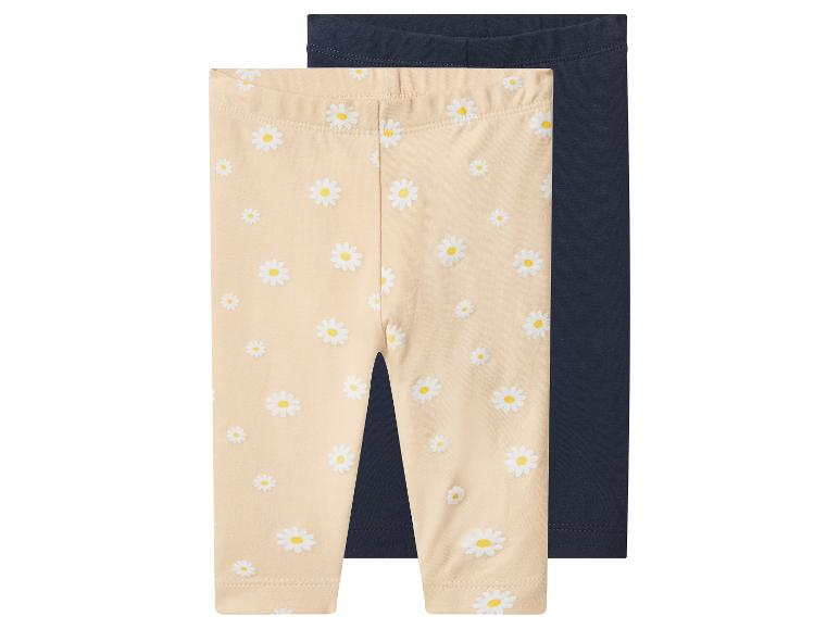 Deux paires de leggings pour bébé : une beige à imprimé marguerites et une bleu foncé unie.