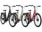 Trois vélos électriques en noir, beige et rose avec des pneus Schwalbe.